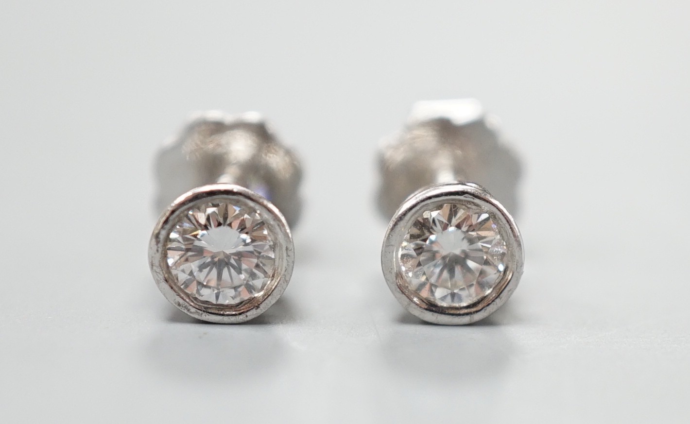 A pair of 750 white metal and collet set solitaire diamond ear studs, gross weight 1.5 grams, stone diameter approx. 3.7mm.